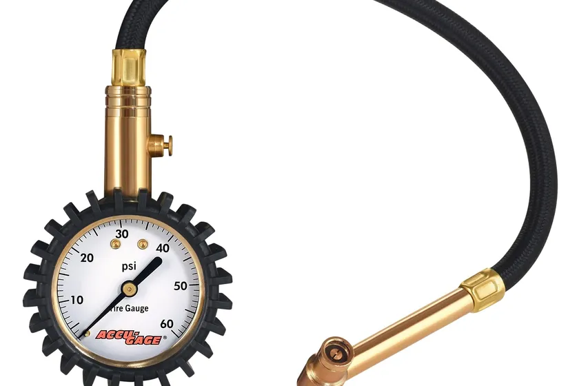 Accu-Gage RRA60X analog dial tire pressure gauge with a black protective rubber guard, hose and right angle chuck