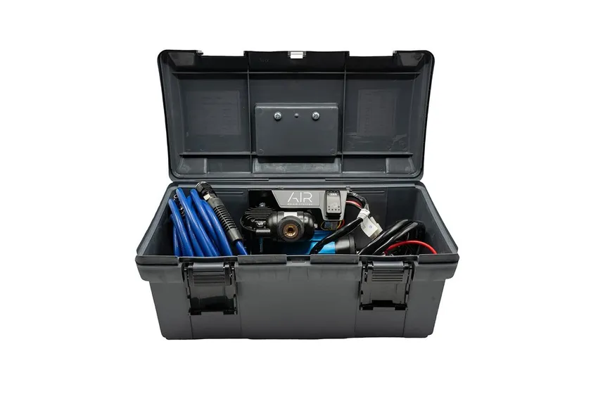 ARB CKMP12 portable 12 volt air compressor in its blue and black carry case with air hose and battery leads