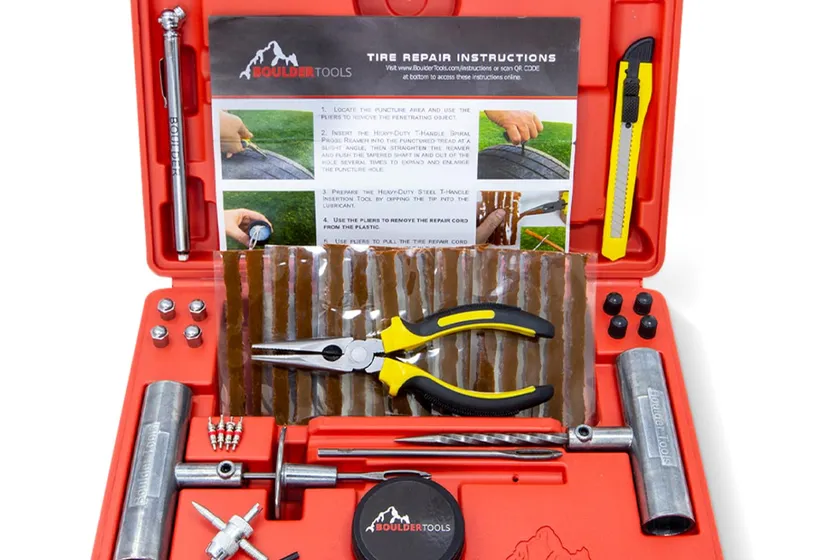 Boulder Tools tire plug kit laid out in its molded hard case with steel T-handle tools, plugs, pliers and a tire pressure gauge