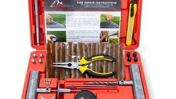 Tire plug kit open in its hard case with steel T-handle tools, repair plugs, pliers and a tire pressure gauge