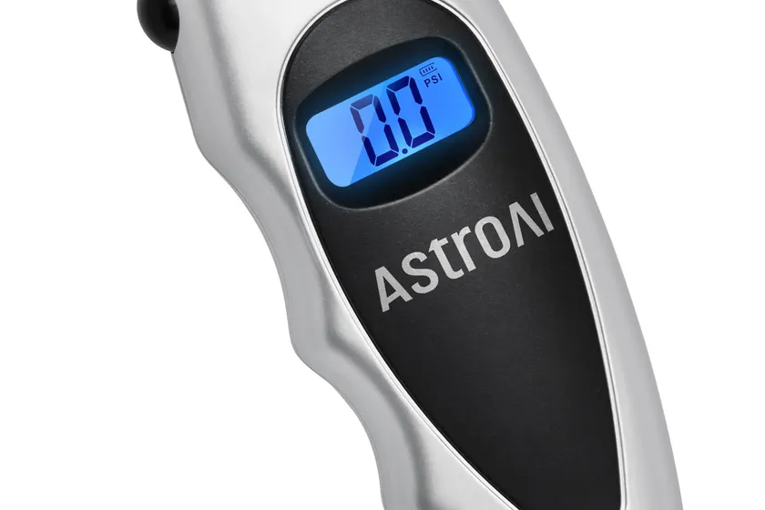 AstroAI silver digital tire pressure gauge with a backlit LCD screen and a black non-slip rubber grip
