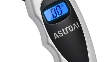 Digital tire pressure gauge with a backlit screen used to check a car tire