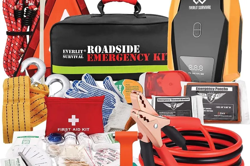 Everlit car emergency kit with jumper cables, a digital tire inflator, safety gloves and a first aid pouch laid out around the carry bag