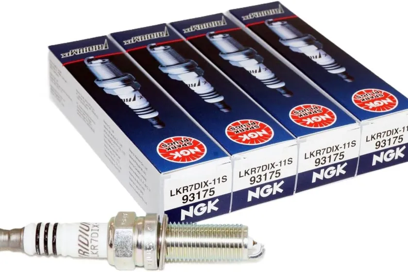 Four NGK LKR7DIX-11S Iridium IX spark plugs standing upright next to their orange and white NGK boxes