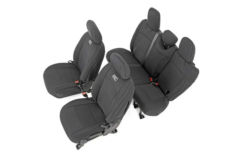 Black Rough Country neoprene front and rear seat covers installed in a four-door Jeep Wrangler JL