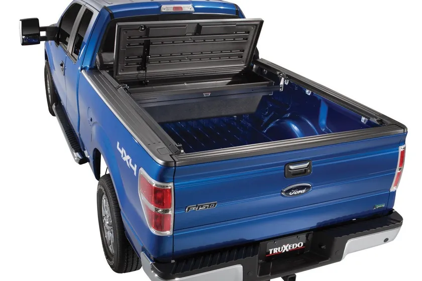 TruXedo TonneauMate black polymer truck tool box mounted under a tonneau cover between bed rails