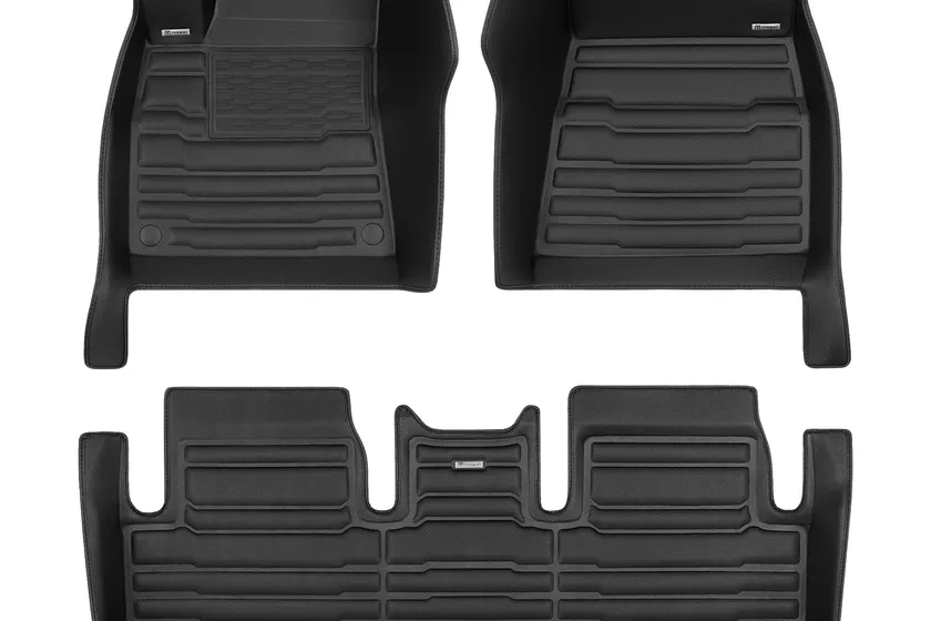 TuxMat black custom fit floor mats with tall raised walls covering a Tesla Model 3 footwell