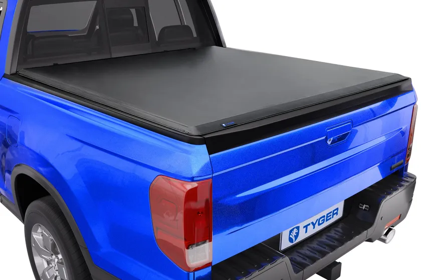 Tyger Auto T1 soft roll-up tonneau cover with black vinyl rolled toward the cab on a Honda Ridgeline bed