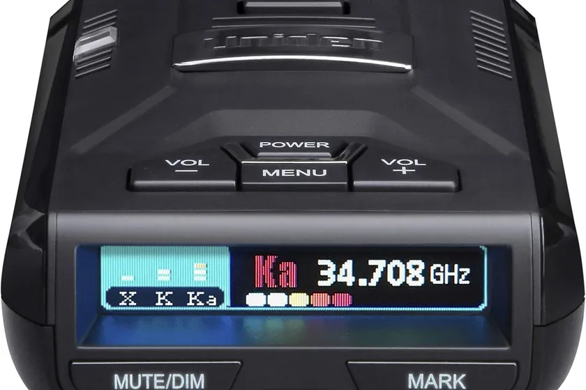 Uniden R3 radar detector with its multi-color OLED display lit up on a windshield mount