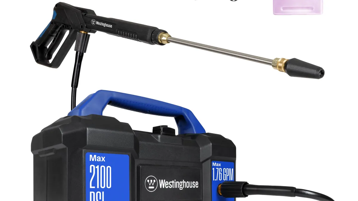 Compact electric pressure washer with a foam cannon set up for washing a car in a driveway